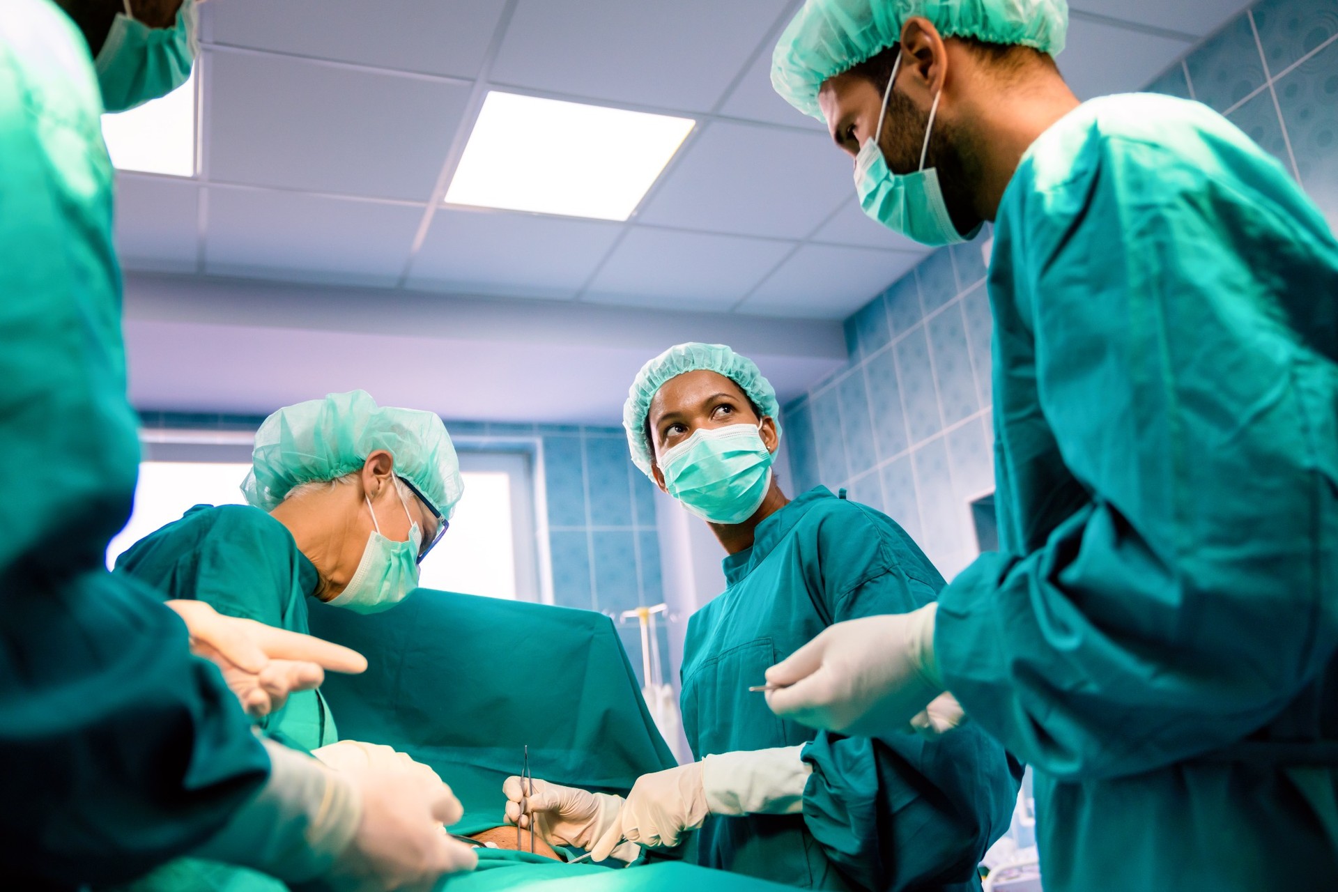 Diverse surgical team in discussion during procedure in operating room