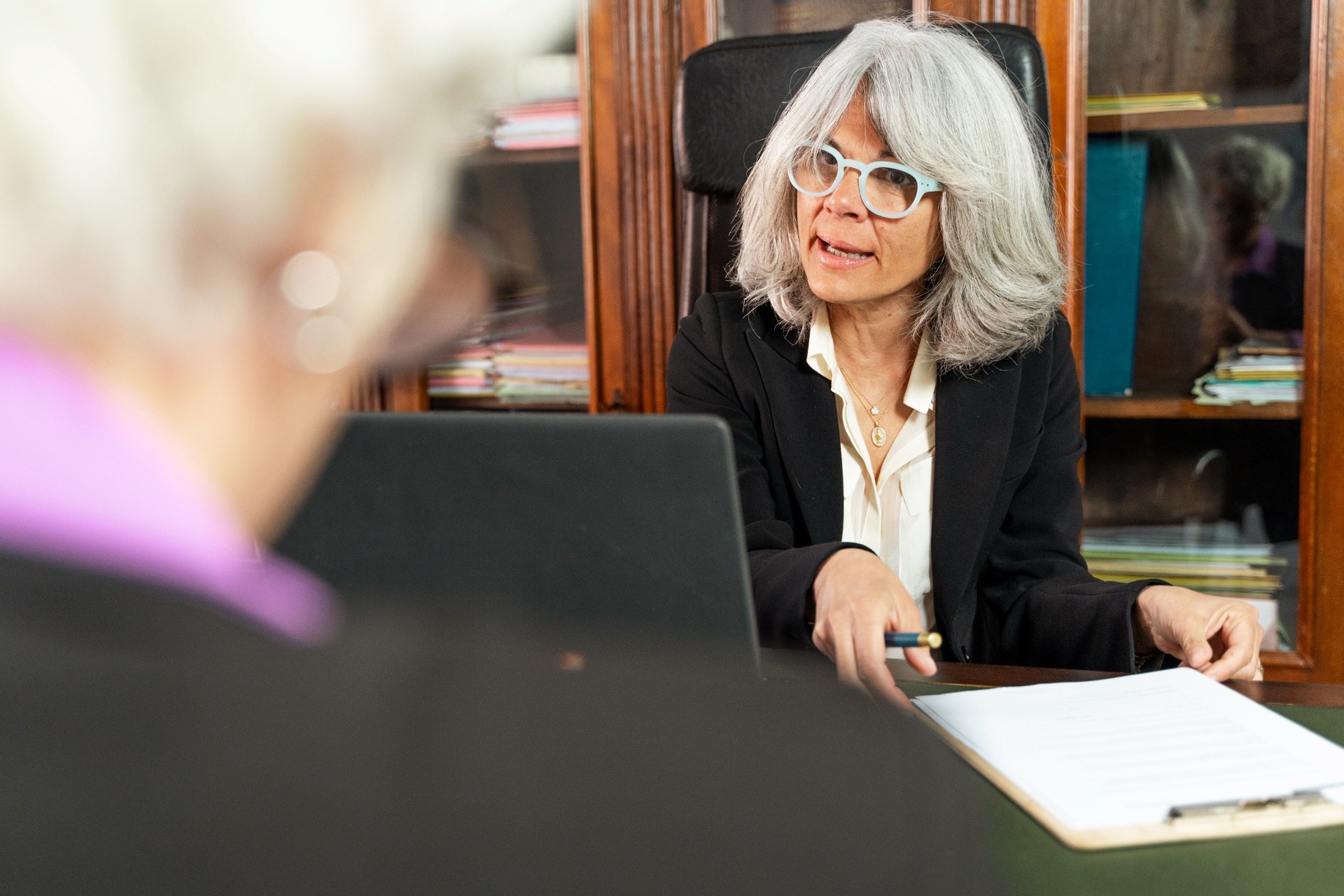 Experienced female lawyer explaining legal documents to elderly client