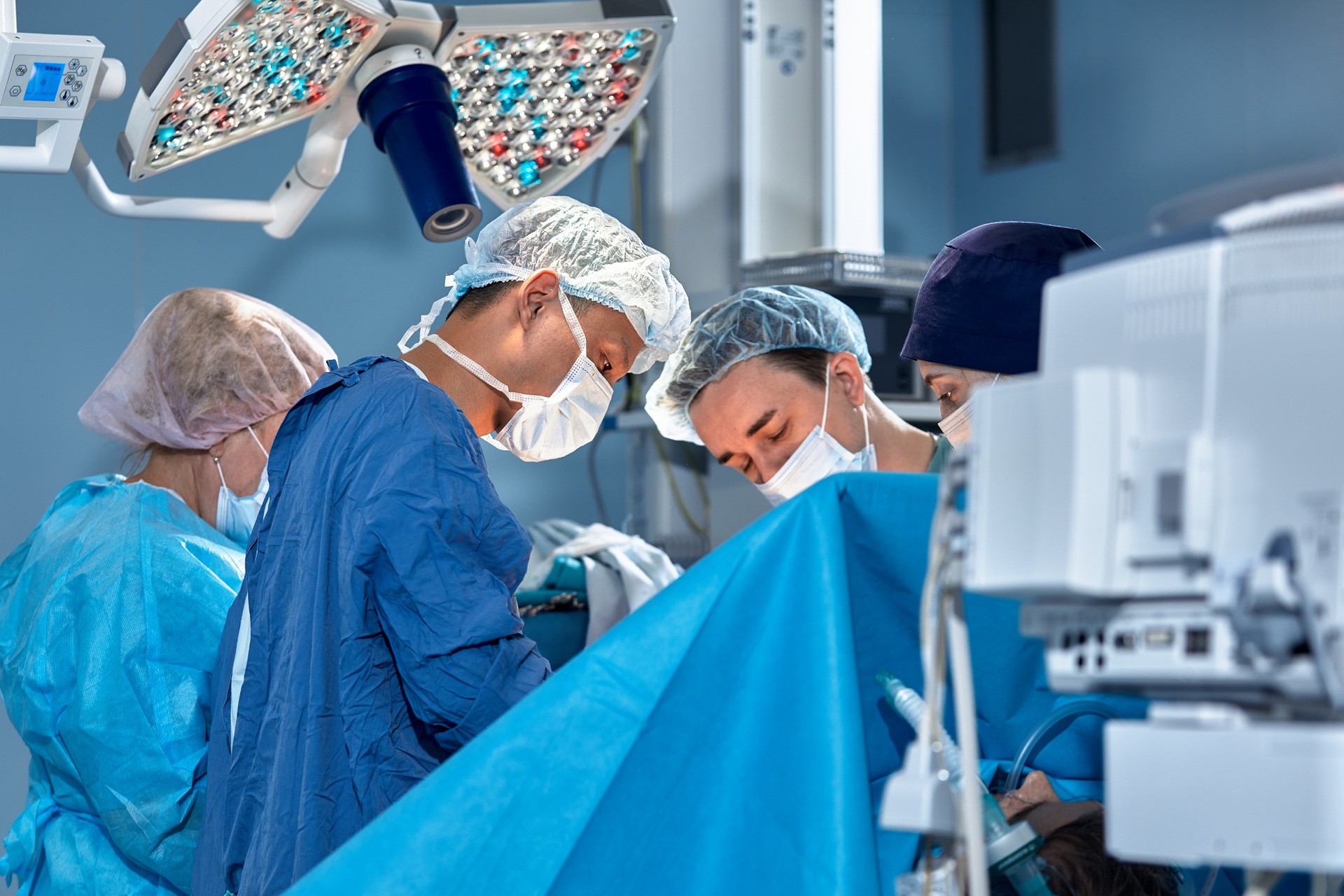 Focused surgical team performing operation under bright lights
