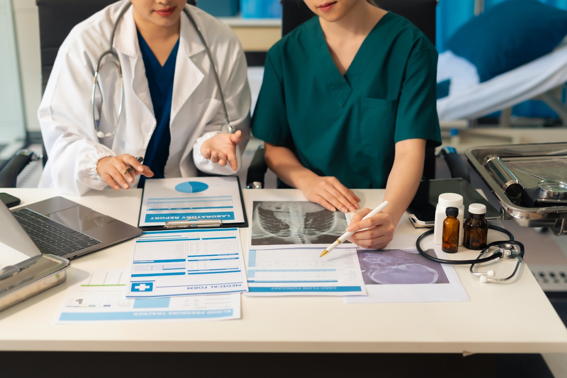 Medical professionals reviewing lab reports and X-rays at desk