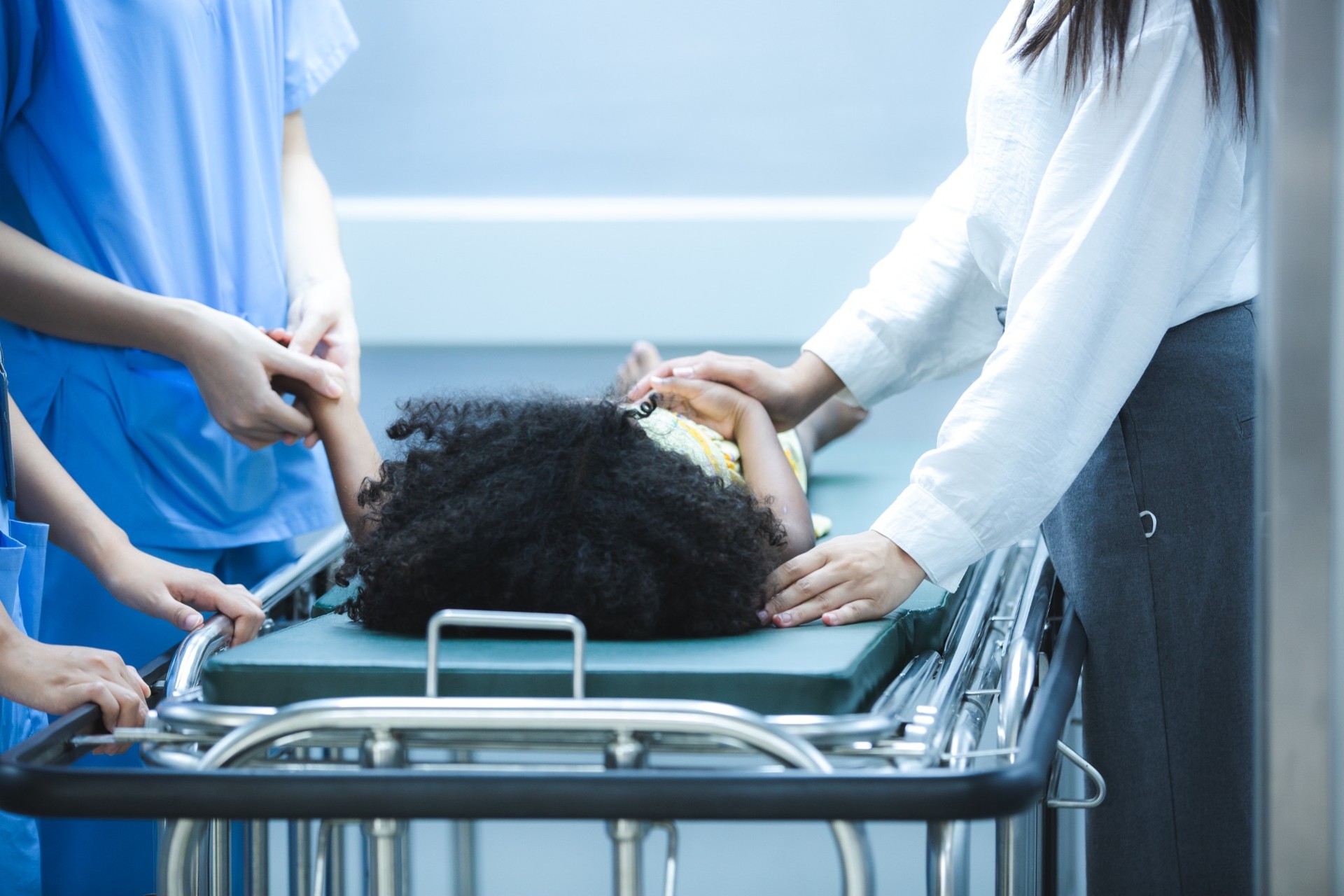 Child receiving urgent medical attention on hospital gurney
