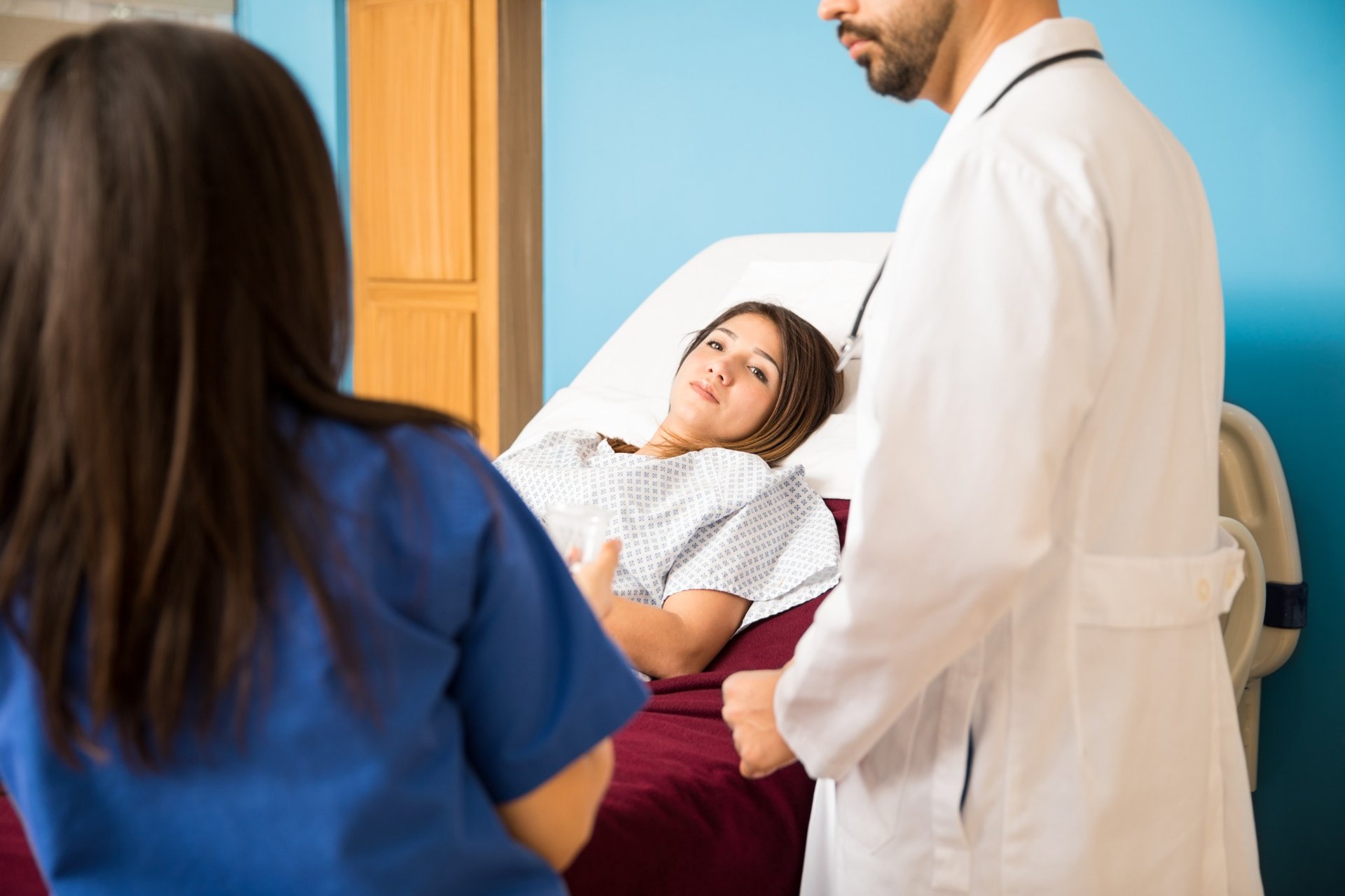 Female patient receiving medical news in hospital bed