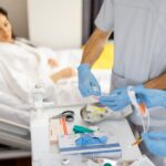 Medical team preparing treatment tools beside hospital bed