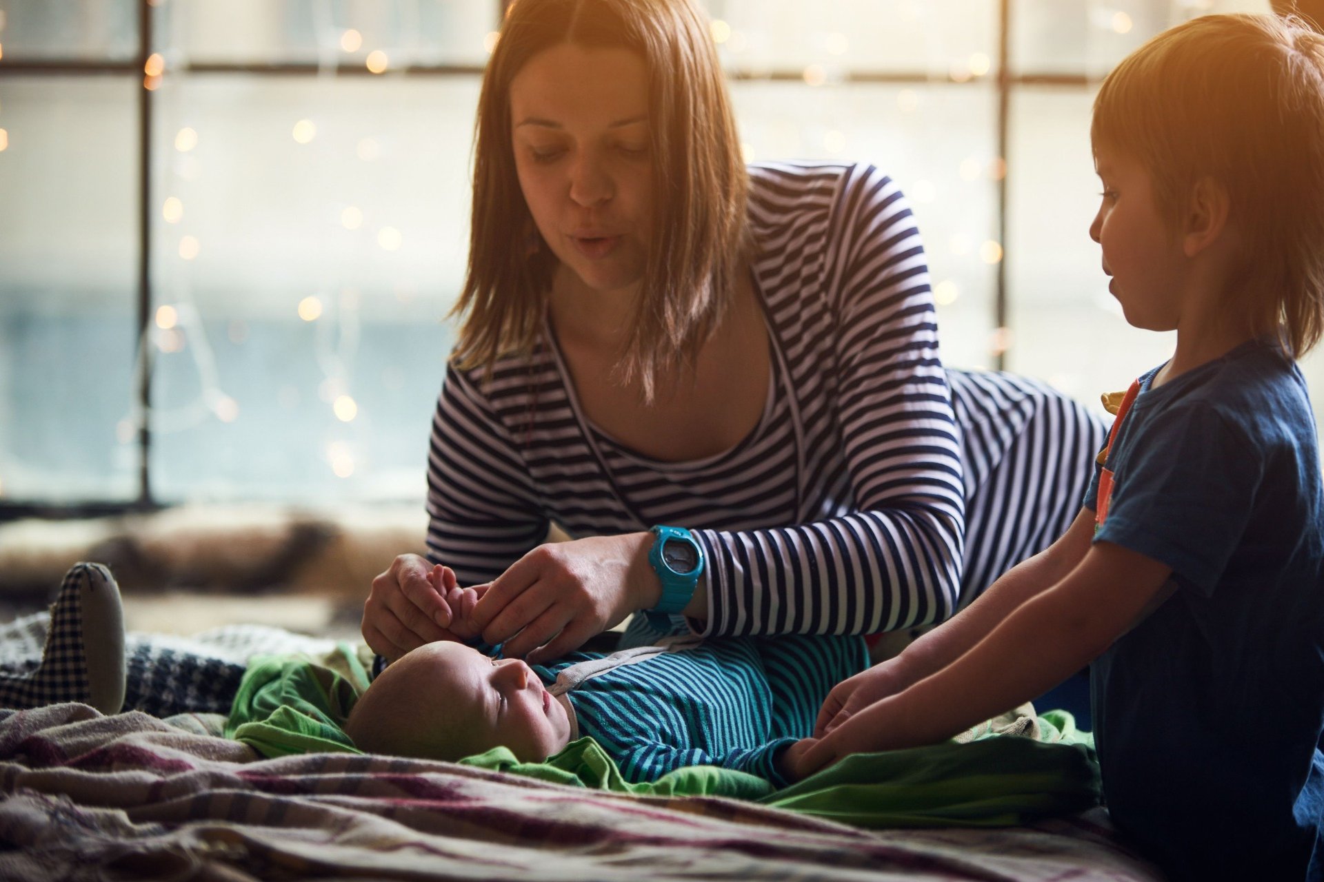Mother bonding with baby and toddler at home