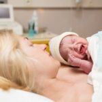 Newborn baby crying during skin-to-skin contact with mother after birth