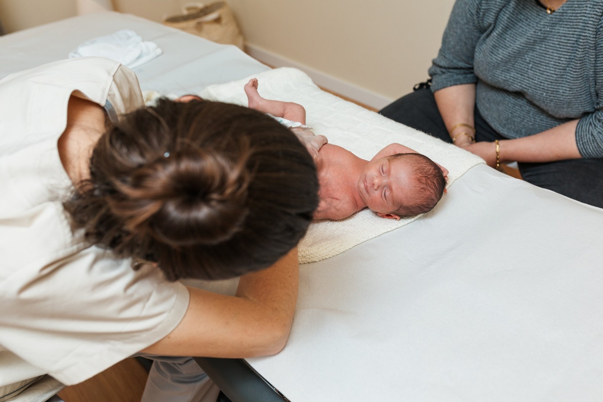 Physiotherapist working with a newborn baby on a table