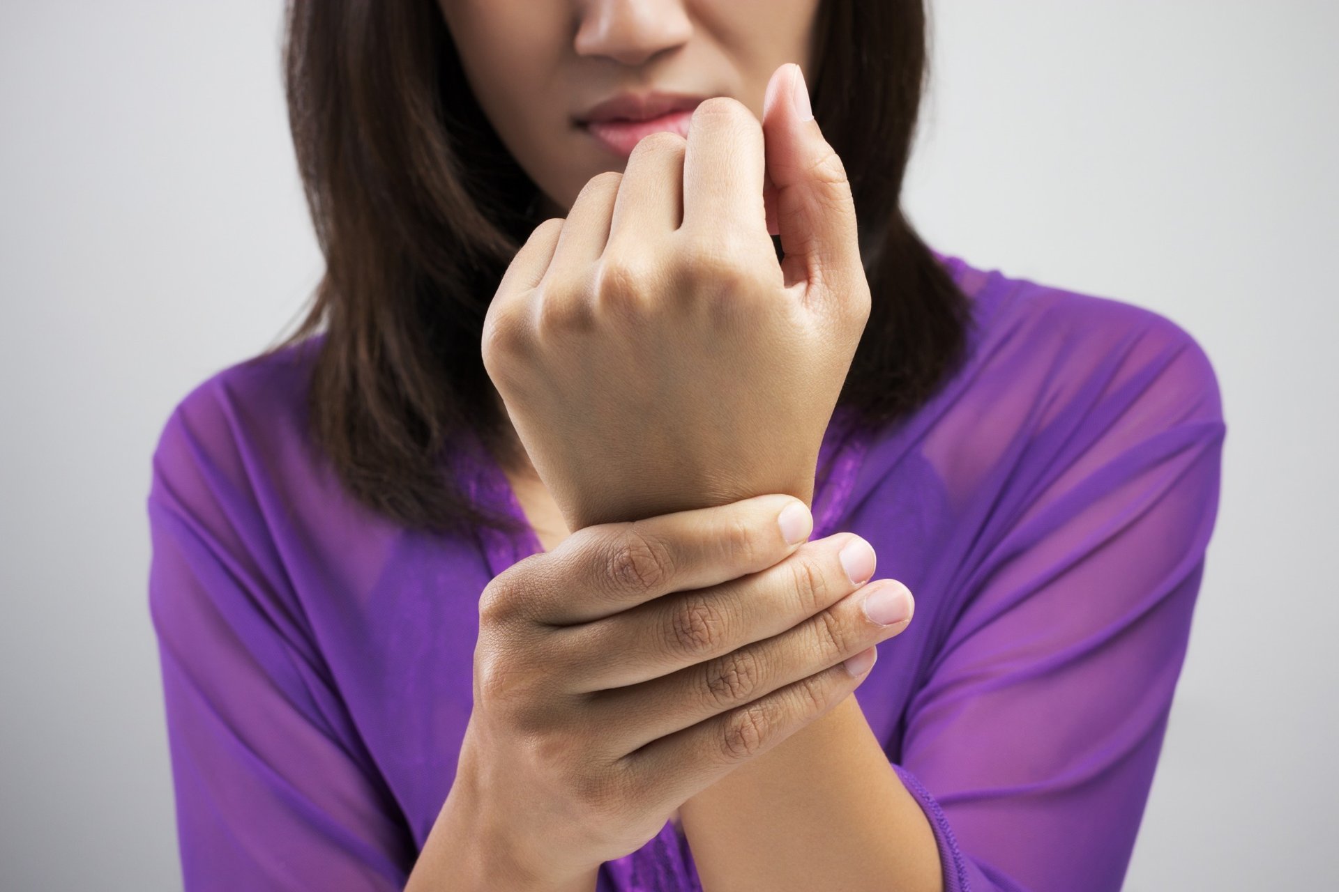 Woman holding wrist in pain due to numbness or injury